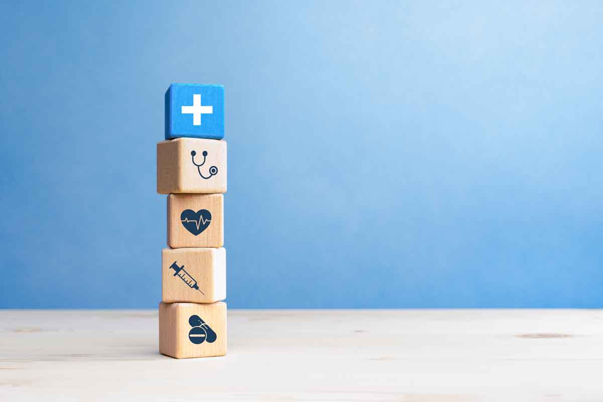 Health insurance concept, wooden blocks with healthcare medical icons on blue background